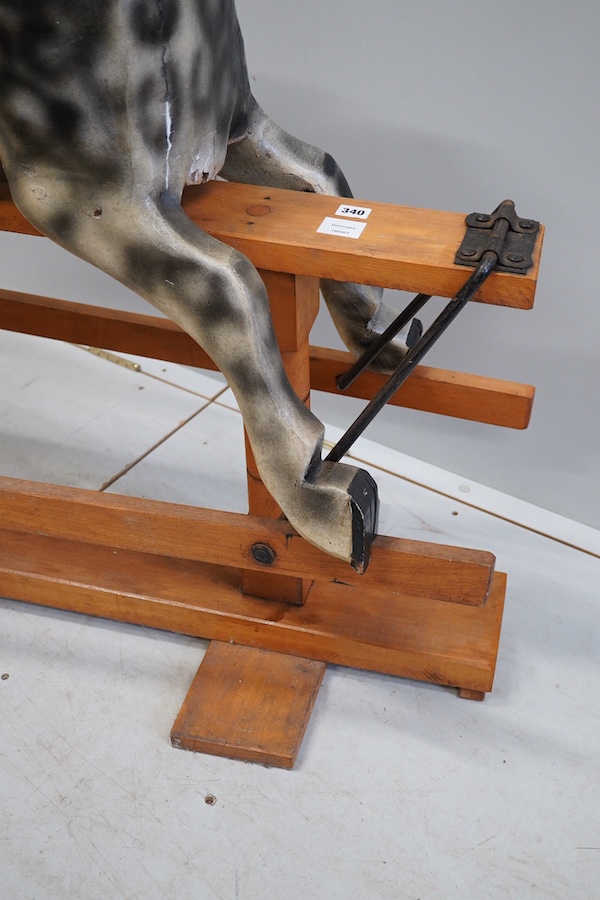 An early 20th century dapple grey rocking horse, on later trestle base, length 132cm. Condition - fair.